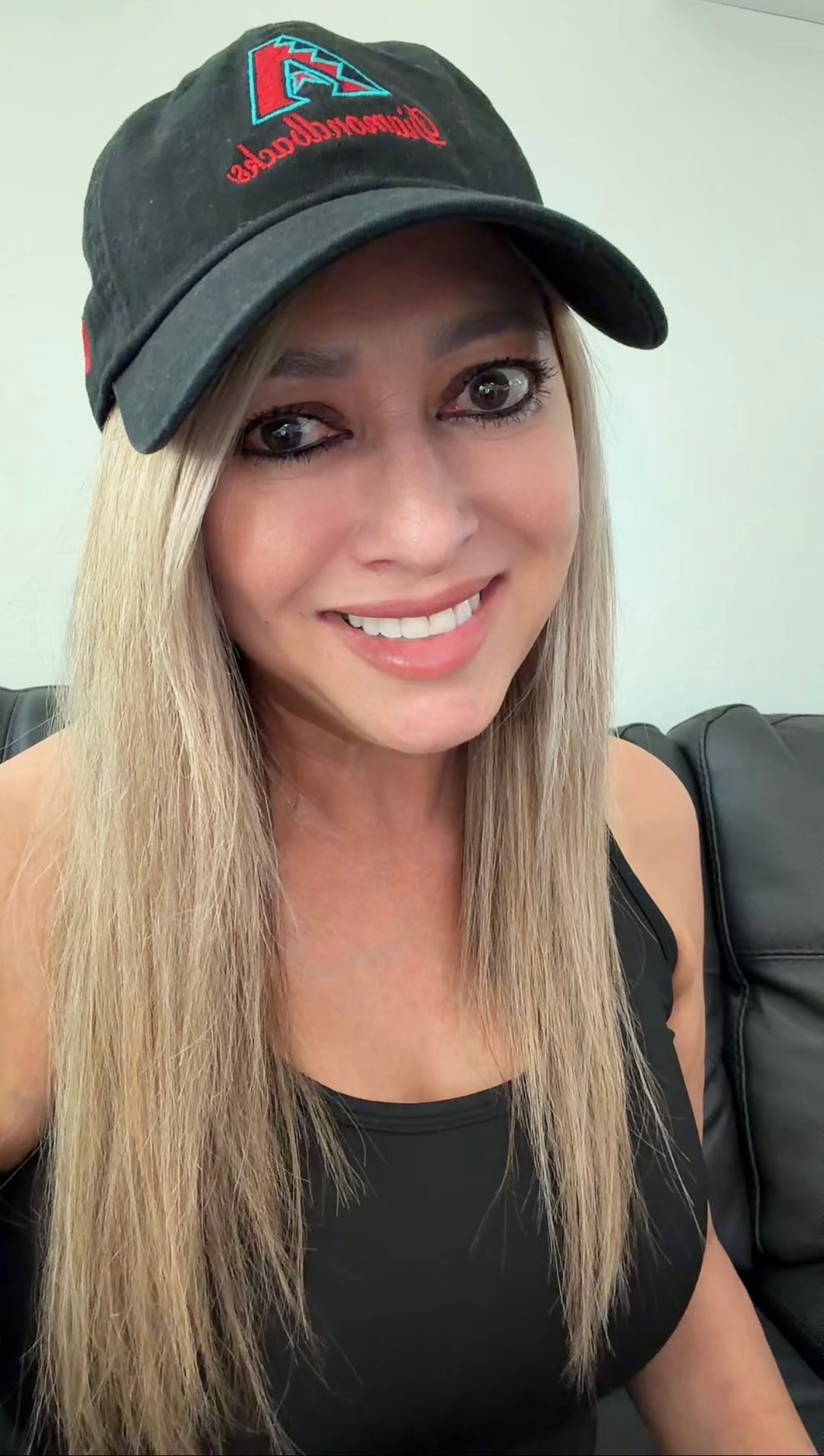 Sabrina Vargas, East Flagstaff real estate agent, smiling in a casual portrait wearing a Diamondbacks cap.