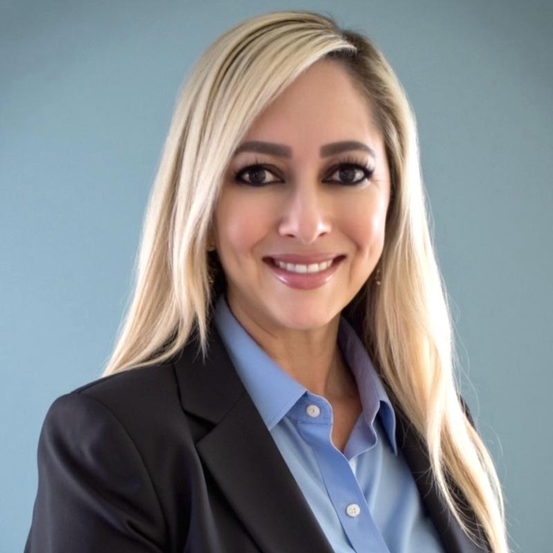 Sabrina Vargas, a East Flagstaff real estate agent with HomeSmart, in a professional headshot against a light blue background.